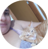 Uma mulher abraçada ao seu gato de cor marrom e branco.