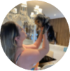 Uma mulher de cabelo longo, segura em suas mãos seu cachorro pequeno.